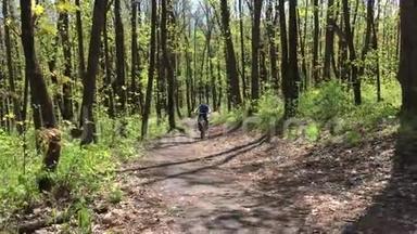 男孩骑着自行车穿过树林